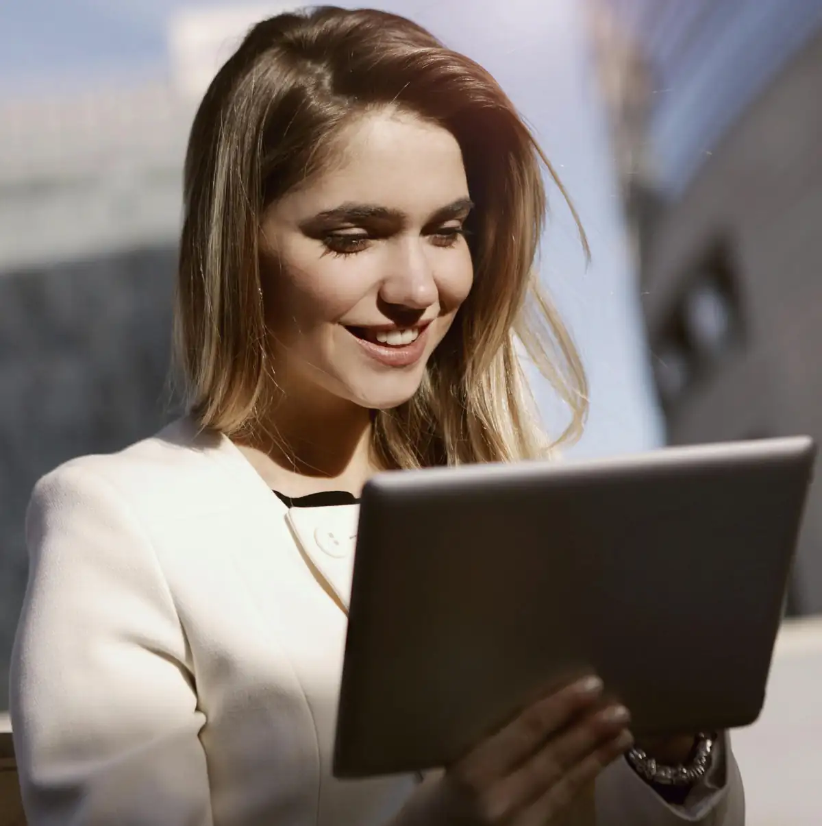 Junge freundliche Frau, die lachend auf ihr Tablet schaut